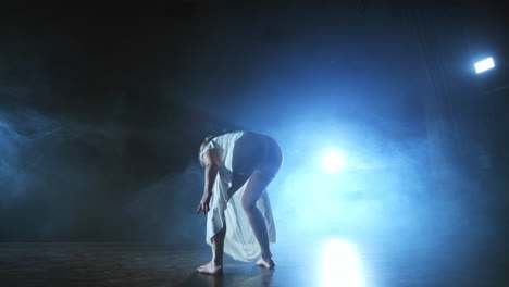 Slow-motion:-female-dancer-on-stage-in-smoke.-Modern-ballet-barefoot-on-stage.